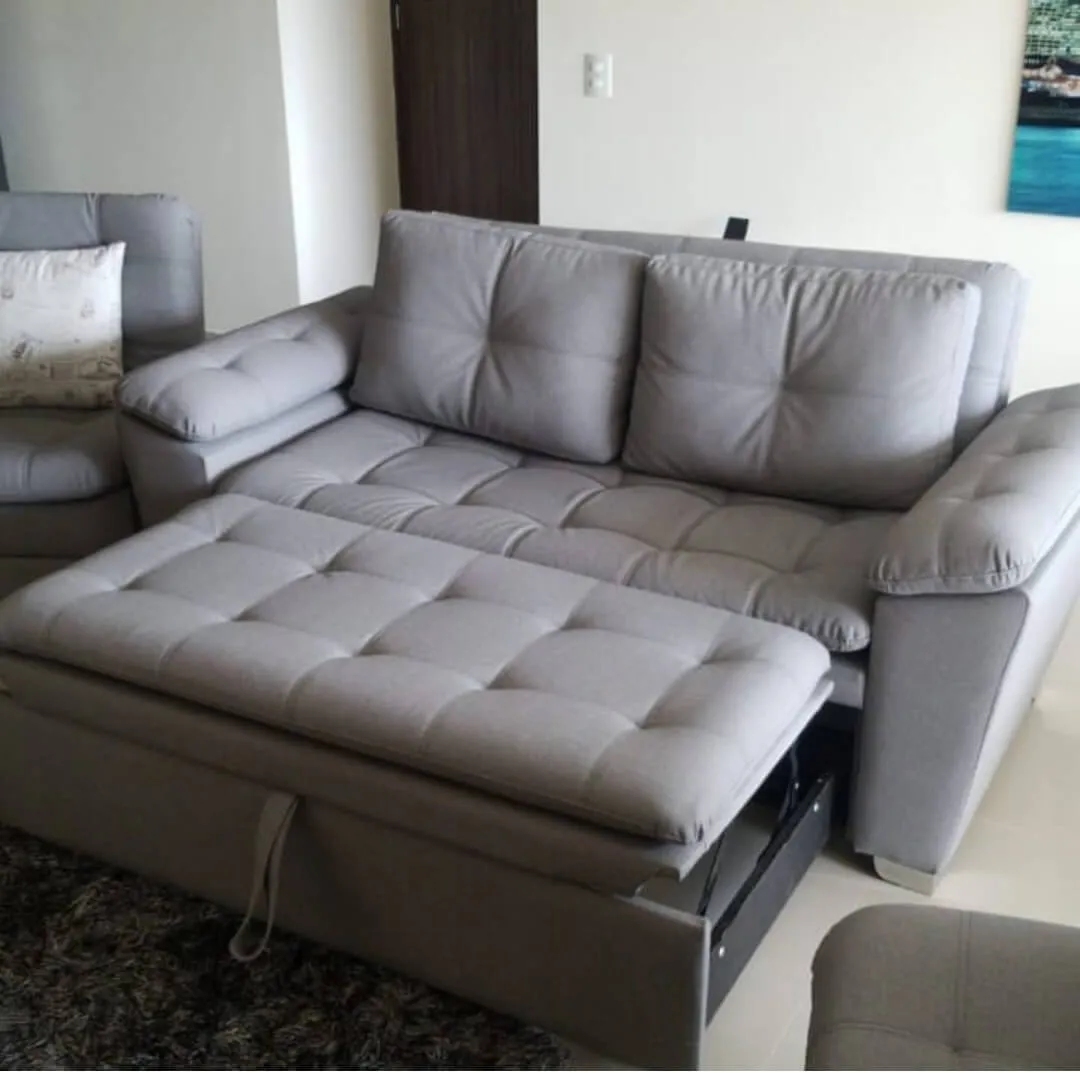 Sofá cama tapizado en gris con capitoné